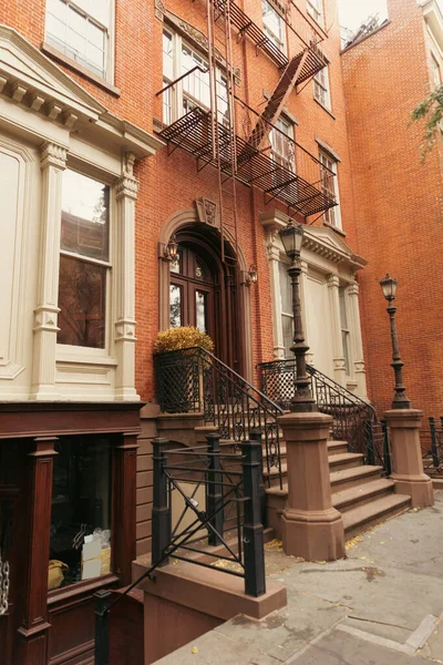 Кирпичный дом с лестницами и белой лепниной на городской улице в Нью-Йорке — стоковое фото