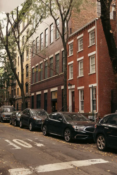 Coches y casas de ladrillo en la calle en la ciudad de Nueva York - foto de stock