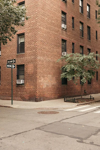 Pointeurs et arbres près d'un immeuble animé dans la rue à New York — Photo de stock
