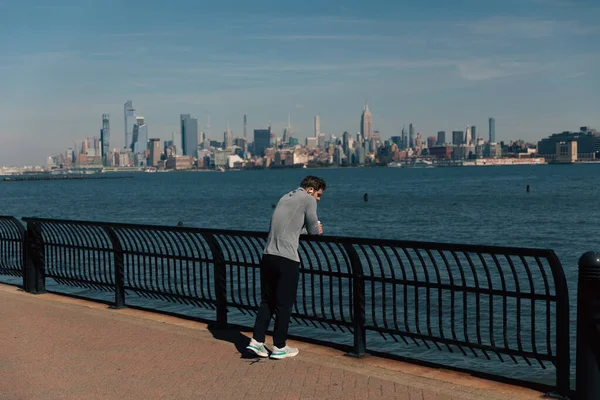 NEW YORK, USA - OCTOBER 11, 2022: Людина стоїть біля паркану на березі річки Гудзон — стокове фото