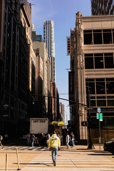 NEW YORK, USA - OCTOBER 11, 2022: People walking on crosswalk between buildings on street — Fotografia de Stock