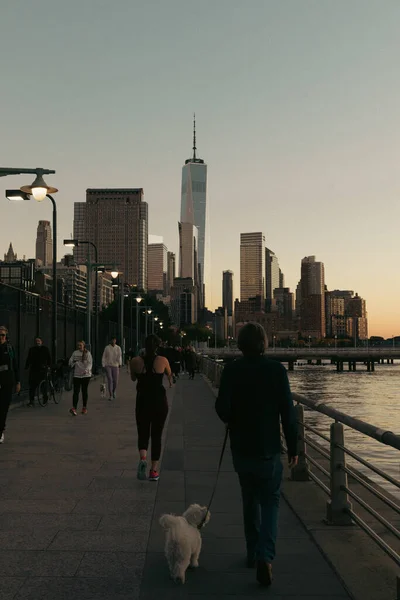 NEW YORK, USA - OCTOBER 11, 2022: People walking on street near Hudson river in evening — стокове фото