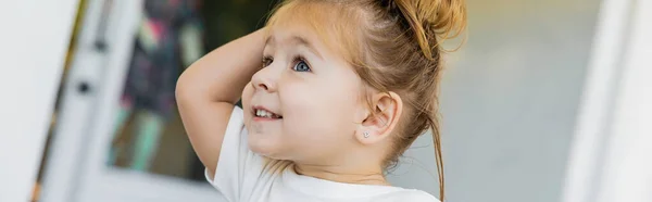 Retrato de niña alegre en camiseta blanca mirando al aire libre, pancarta - foto de stock
