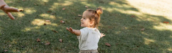 Menina criança feliz de pé com as mãos estendidas enquanto joga no parque, banner — Fotografia de Stock