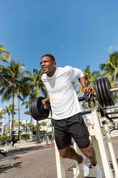 Visão de baixo ângulo do esportista afro-americano trabalhando no ginásio ao ar livre na praia de Miami — Fotografia de Stock