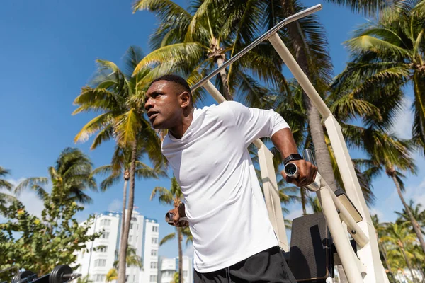 Vue à faible angle du sportif afro-américain travaillant sur la plage de Miami — Photo de stock