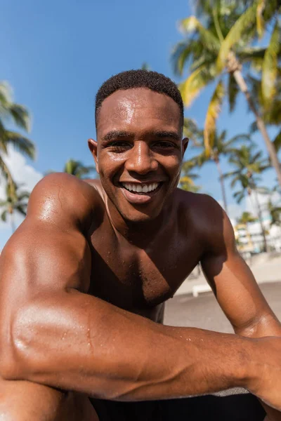 Портрет безрубашечного и счастливого африканского спортсмена, смотрящего в камеру — стоковое фото