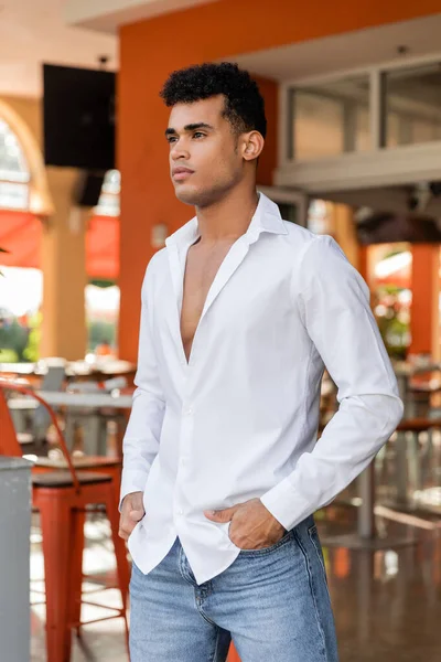 Homem cubano de camisa branca e jeans posando no café ao ar livre na rua urbana em Miami, praia sul — Fotografia de Stock