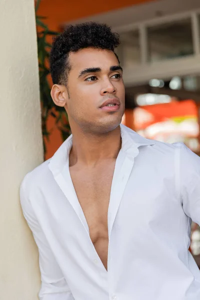 Retrato de un joven y guapo hombre cubano de camisa blanca mirando hacia Miami, playa sur - foto de stock