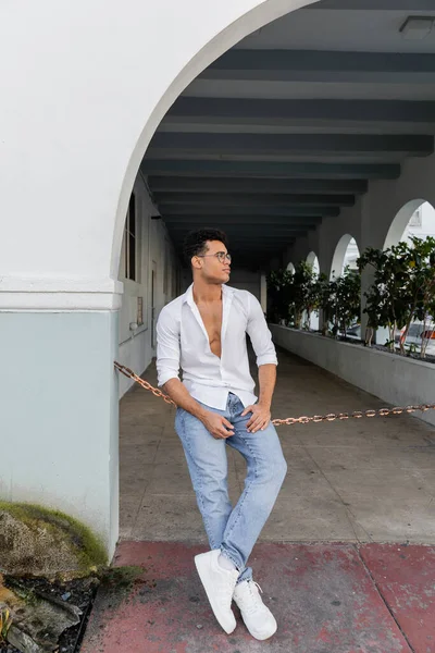 Pleine longueur de jeune homme cubain élégant en chemise et lunettes de vue de forme ronde élégant à Miami — Photo de stock