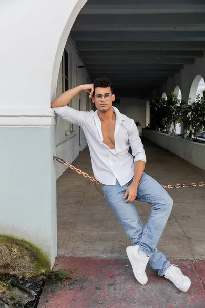 Comprimento total de homem cubano elegante em camisa branca e jeans na rua urbana em Miami — Fotografia de Stock