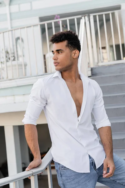 Homme cubain en chemise blanche et jeans regardant loin sur la rue urbaine à Miami — Photo de stock