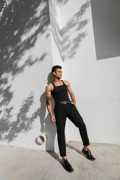 Sexy jeune homme cubain posant près de mur blanc avec ombre sur la rue urbaine à Miami, plage du sud — Photo de stock