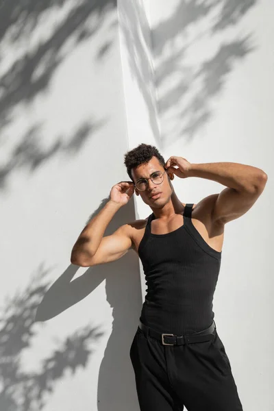Fashionable cuban man standing near building with shadow on street in Miami, south beach — Stock Photo
