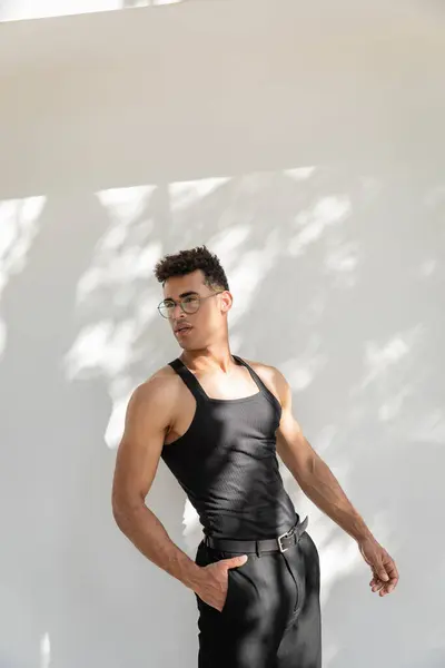 Jeune homme cubain à la mode et beau en lunettes de soleil et tenue noire posant à Miami — Photo de stock