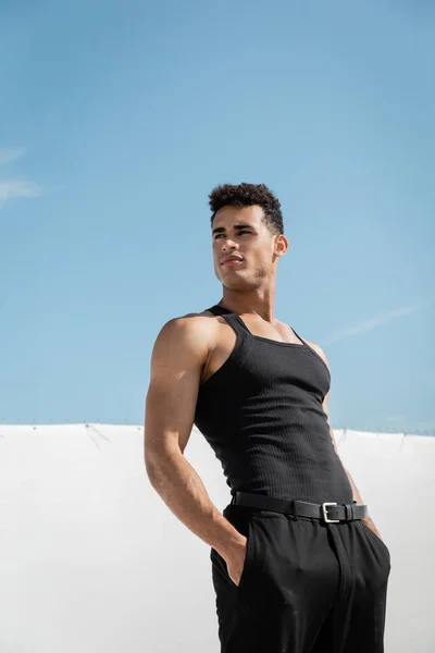 Jeune homme cubain musclé en t-shirt et pantalon noir sans manches posant à Miami, plage du sud — Photo de stock