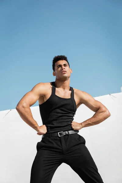 Muscular cuban man in stylish black outfit holding hands on hips in Miami, south beach — Stock Photo