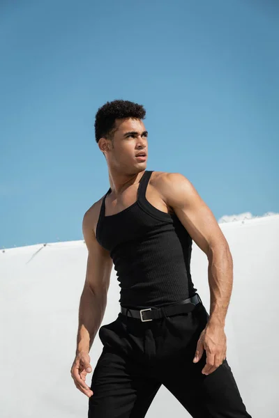 Portrait d'un homme cubain fort et élégant en tenue noire tendance regardant ailleurs à Miami, plage du sud — Photo de stock