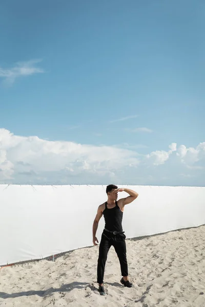 Homme cubain musclé et jeune en tenue élégante couvrant le visage de la lumière du soleil à Miami, plage sud — Photo de stock