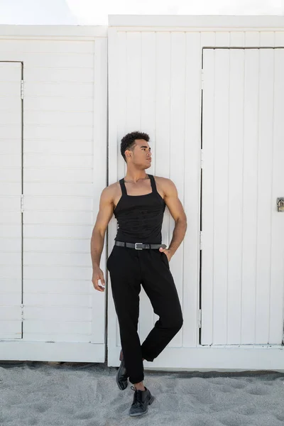Atlético hombre cubano en traje elegante cogido de la mano en el bolsillo de los pantalones en Miami, sur de la playa - foto de stock