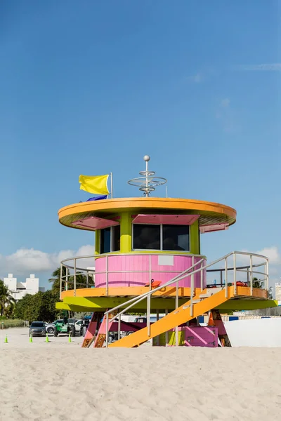 Colorata torre bagnino spiaggia con bandiere in cima sulla sabbia con cielo blu sullo sfondo a Miami — Foto stock