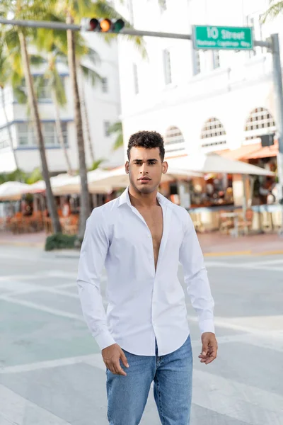 Портрет молодого кубинца в джинсах и белой рубашке, смотрящего в камеру в Майами, южный пляж — стоковое фото