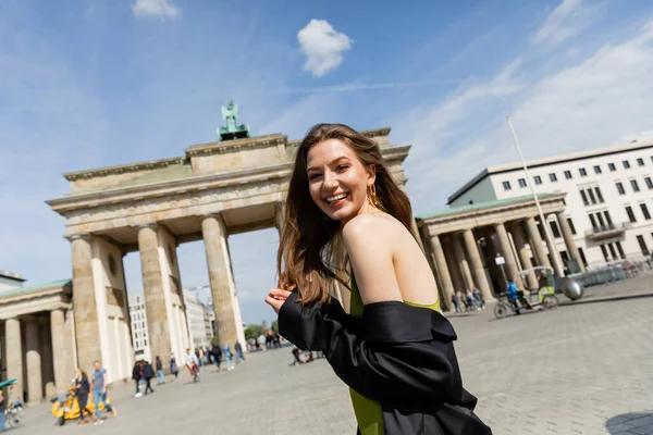 BERLÍN, ALEMANIA - 13 DE MAYO DE 2022: Mujer feliz parada cerca de la Puerta de Brandeburgo - foto de stock