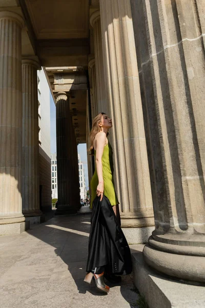 Elegante giovane donna in abito di seta con giacca nera e in piedi a Berlino, Germania — Foto stock