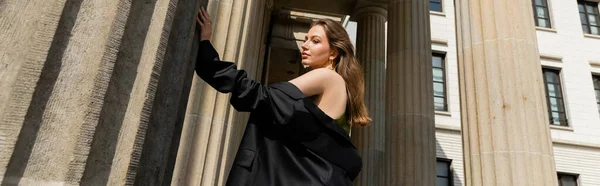 Elegante giovane donna in abito di seta con giacca nera e in piedi a Berlino, banner — Foto stock