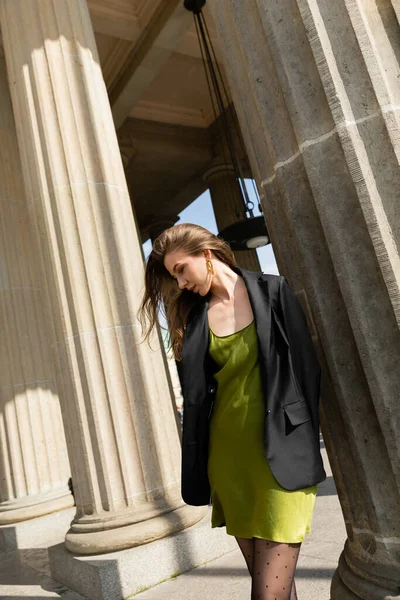 Elégante femme blonde en robe de soie verte et veste noire debout à Berlin — Photo de stock