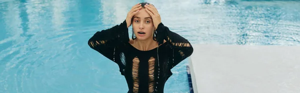 Luxusresort in Miami, sexy Frau mit gebräunter Haut und nassem schwarzen Kleid, die in die Kamera schaut, im öffentlichen Schwimmbad posiert und ihren Sommerurlaub genießt, ohne Make-up-Look, Banner — Stockfoto