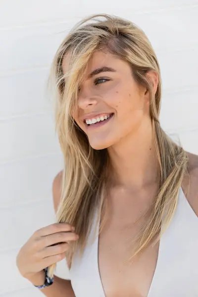 A young, beautiful blonde woman in a white top smiles joyfully at Miami Beach. — Stock Photo