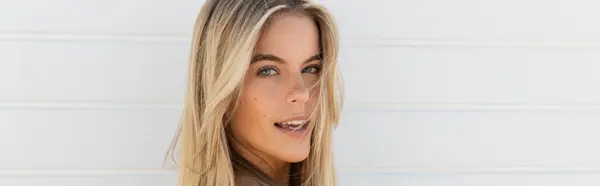 Eine junge, schöne Frau mit langen blonden Haaren lächelt freudig unter der Miami-Strandsonne. — Stockfoto