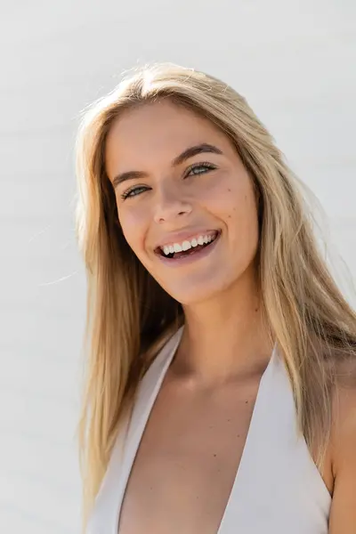 Eine junge, schöne blonde Frau in Miami Beach, die ein weißes Oberteil trägt, lächelt freundlich in die Kamera. — Stockfoto