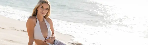 Uma jovem loira exala serenidade em um biquíni branco na ensolarada Miami Beach, personificando relaxamento e beleza natural. — Fotografia de Stock