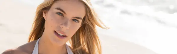 Une jeune, belle femme blonde posant dans un haut de bikini sur une plage de sable fin de Miami sous le soleil éclatant, respirant la confiance. — Photo de stock