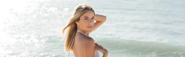 Eine junge und schöne blonde Frau steht anmutig am Miami Beach und blickt mit einem Gefühl von Ruhe und Frieden auf den weiten Ozean.. — Stockfoto
