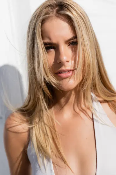 Eine junge, schöne blonde Frau posiert anmutig am Miami Beach, ihr langes Haar fließt im Wind. — Stockfoto