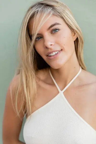 Une jeune femme blonde dans un haut blanc frappant une pose pour une photo dans un cadre tropical Miami. — Photo de stock