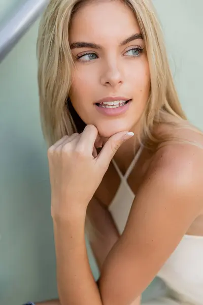 Eine junge und schöne blonde Frau posiert anmutig in einem fließenden weißen Kleid für ein fesselndes Porträt in Miami. — Stockfoto