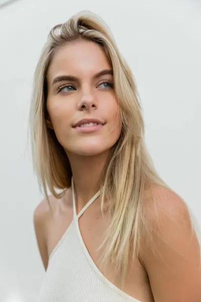 Eine junge und schöne blonde Frau mit langen Haaren trägt ein weißes Oberteil in Miami. — Stockfoto