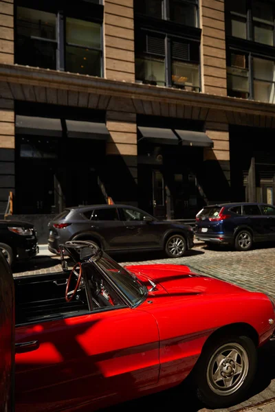 Roter Oldtimer und andere Fahrzeuge, die in der Nähe von Gebäuden auf der Straße in New York City geparkt sind, urbane Szene — Stockfoto