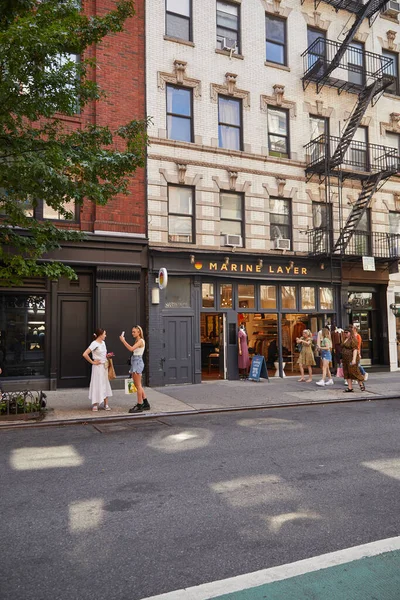 NOVA IORQUE, EUA - NOVEMBRO 26, 2022: pedestres perto da loja de roupas da camada marinha no distrito comercial — Fotografia de Stock
