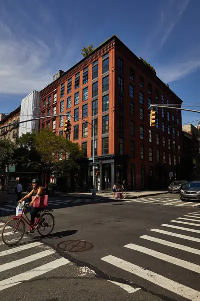 НЬЮ-ЙОРК, США - 26 ноября 2022 года: велосипедист и легковые автомобили пересекают дорогу с светофорами в центре города — стоковое фото