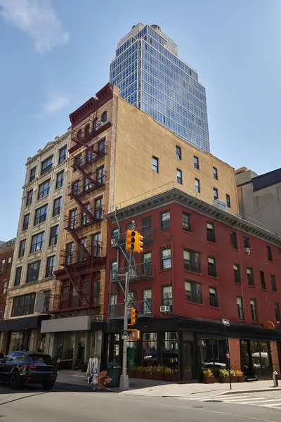 Gratte-ciel moderne et bâtiments anciens près de la route avec feu de circulation dans la ville de New York, paysage de rue — Photo de stock