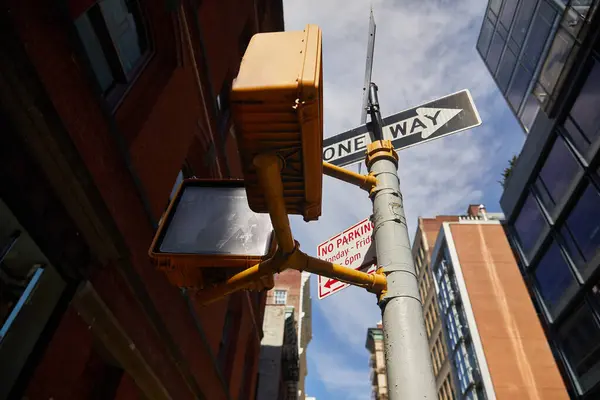 Vista de ángulo bajo del poste de la calle con señales de tráfico y semáforos en la ciudad de Nueva York, señalización urbana - foto de stock