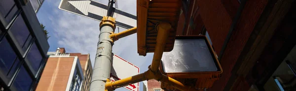 Вигляд на низький кут світлофора і дорожній знак, що показує напрямок у нью-йоркському блоці, банер — стокове фото