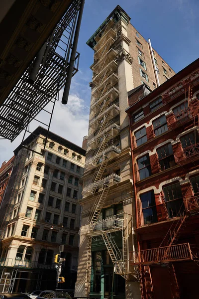 Edifício com escadas de escada de incêndio na rua outonal no centro da cidade de Nova Iorque, vista de baixo ângulo — Fotografia de Stock