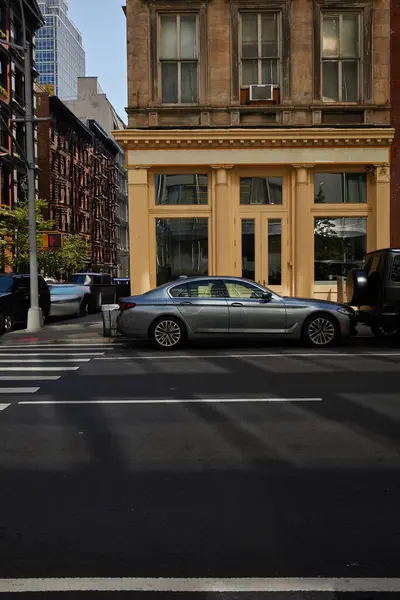 Coches en el cruce de peatones cerca del edificio con vitrinas de vidrio en la avenida en Nueva York, vibraciones de la ciudad - foto de stock