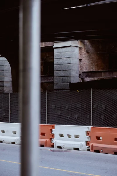 Дорога с пластиковыми дорожными барьерами под мостом в Нью-Йорке, атмосфера мегаполиса — стоковое фото